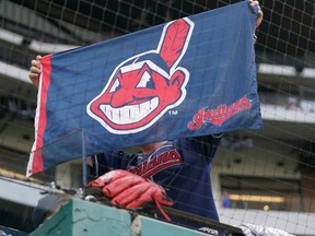 A Cleveland Indians fan holds up the Indians flag during the ninth inning of a baseball game against the Texas Rangers at Globe Life Field.