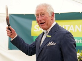 Prinz Charles, Patron der Samariter, gestikuliert vor dem Anschneiden eines Kuchens während eines Besuchs in Gloucester und der Bezirksstelle der Samariter in Gloucester, um ihr 50-jähriges Bestehen in Gloucester, Großbritannien, am 26. Oktober 2021 zu feiern.