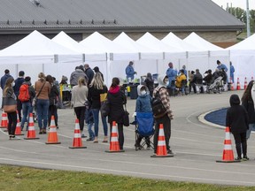 People line up at a COVID-19 testing site in St. Lambert, Que. on Friday, September 25, 2020.