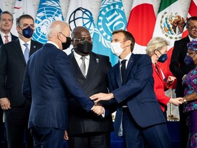 U.S. President Joe Biden shakes hands with French President Emmanuel Macron as Democratic Republic of the Congo President Felix Tshisekedi looks on during a family photo session on the sidelines of the G20 summit at the La Nuvola in Rome, Italy October 30, 2021.