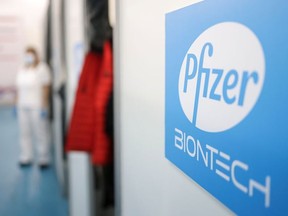 A health-care worker waits in front of a booth where people receive doses of Pfizer's COVID-19 vaccine at Belgrade Fair vaccination centre in Belgrade, Serbia, Oct. 15, 2021.