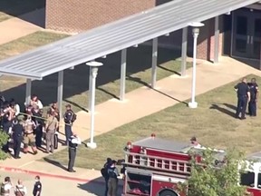 Police and firefighters are seen at the scene of a shooting at Timberview High School in Arlington, Texas on Oct. 6, 2021.