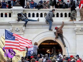 A mob of supporters of U.S. President Donald Trump fight with members of law enforcement at a door they broke open as they storm the U.S. Capitol Building in Washington, U.S., January 6, 2021.