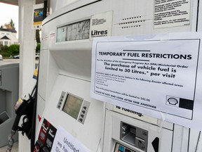 Signs indicating temporary fuel restrictions and the lack of gasoline are seen on gas-station pumps in Vancouver on Nov. 20.