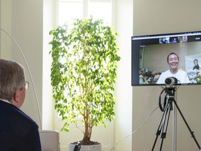 A handout photo posted on the International Olympic Committee website on Nov. 21, 2021 shows IOC President Thomas Bach holding a video call with Chinese tennis star Peng Shuai, as international pressure mounted for information about her wellbeing.