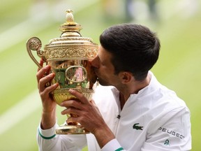 Novak Djokovic celebrates with the trophy after winning his Wimbledon men's final final match against Matteo Berrettini at the All England Lawn Tennis and Croquet Club in London, July 11, 2021.