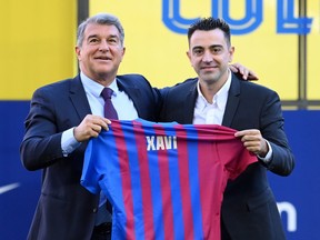 New FC Barcelona Head Coach Xavi Hernandez (R) and Joan Laporta, President of FC Barcelona, pose for a photo during a press conference at Camp Nou on November 8, 2021 in Barcelona, Spain.