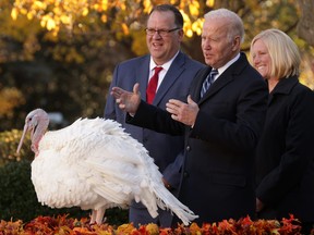 Accompanied by Chairman of National Turkey Federation Phil Seger, left, and turkey grower Andrea Welp, right, U.S. President Joe Biden participates in the 74th annual Thanksgiving turkey pardon of Peanut Butter in the Rose Garden of the White House Nov. 19, 2021 in Washington, D.C.