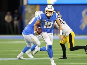 Justin Herbert (10) of the Los Angeles Chargers carries the ball against the Pittsburgh Steelers during the second half at SoFi Stadium on November 21, 2021 in Inglewood, California.
