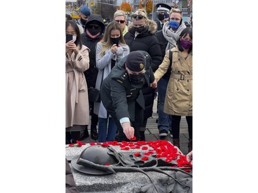 A member of the Canadian Armed Forces places a poppy on the Tomb of the Unknown Soldier following Remembrance Day services at the National War Memorial on Thursday, Nov. 11, 2021.