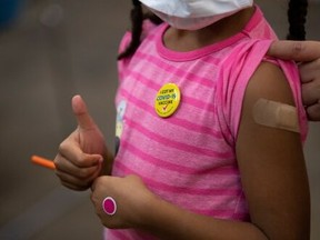 Josclyn Ledisma, 5, gives a thumbs up after receiving her first dose of COVID vaccine inside Mary's Center in Washington, D.C., Nov. 3, 2021.
