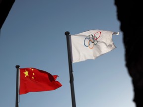 The Chinese and Olympic flags flutter at the headquarters of the Beijing Organizing Committee for the 2022 Olympic and Paralympic Winter Games in Beijing, China, Nov. 12, 2021.