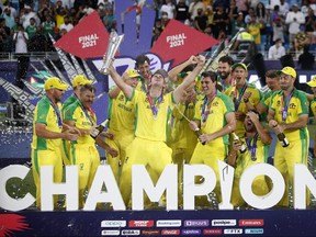 Australia captain Aaron Finch celebrates with the trophy and his teammates after winning the ICC Men’s T20 World Cup in Dubai yesterday.