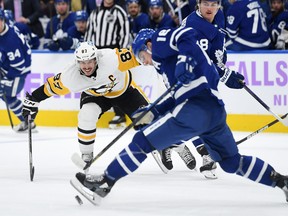 Pittsburgh Penguins forward Sidney Crosby (87) pursues a loose puck with Toronto Maple Leafs forward Mitch Marner (16) in the third period at Scotiabank Arena.