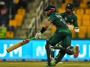 Pakistan's Mohammad Rizwan (L) with Mohammad Hafeez run between the wickets during the ICC men's Twenty20 World Cup cricket match between Namibia and Pakistan at the Sheikh Zayed Cricket Stadium in Abu Dhabi on Tuesday. 
/ AFP) (Photo by INDRANIL MUKHERJEE/AFP via
