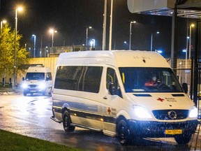 A Red Cross van transporting passengers of flights from South Africa who have tested positive for COVID-19 drives to a hotel where they will be quarantined on Nov. 27, 2021 at Amsterdam's Schiphol airport.