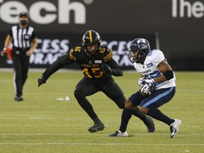 Argonauts’ Chandler Worthy tries to put a move on Ticats linebacker Jovan Santos-Knox during their Oct. 11 game in Hamilton. The teams meet for the fourth and final time in the regular season this Friday at BMO Field with first place in the East up for grabs.