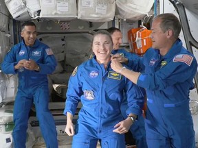 This NASA TV frame grab image captured on November 11, 2021 shows astronaut Tom Marshburn pin the official flown NASA astronaut insignia on Kayla Barron after the Crew-3 Crew Dragon "Endurance" successfully docked with the International Space Station.