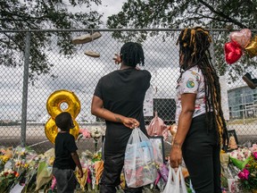 A family views a memorial outside of NGR Park on November 9, 2021 in Houston, Texas.
