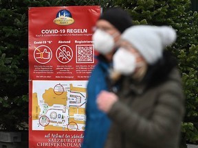 A sign displays rules for visitors of the Christmas market amid the novel coronavirus COVID-19 pandemic in Salzburg, on November 19, 2021.