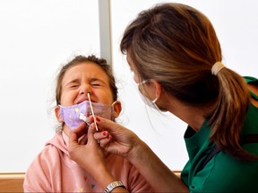 A girl performs a COVID-19 rapid antigen test in a primary school, as Austrian schools open for pupils after summer holidays, in Vienna, Austria, Sept. 6, 2021.