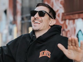 Comedian Andrew Schulz laughing.