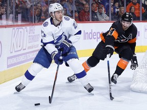 Brayden Point of the Tampa Bay Lightning tries to pass past Sean Couturier of the Philadelphia Flyers at Wells Fargo Center on November 18, 2021 in Philadelphia.