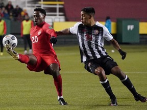 Team Canada's Jonathan David (20) takes control of the ball while evading Team Costa Rica's Orlando Calderon (14) during a FIFA 2022 World Cup qualifier soccer match held at Commonwealth Stadium in Edmonton.