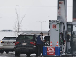 People pump gas into their cars at Costco in Calgary on Thursday, March 25, 2021.