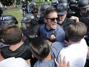 White nationalist Richard Spencer (C) and his supporters clash with Virginia State Police in Emancipation Park after the "Unite the Right" rally was declared an unlawful gathering August 12, 2017 in Charlottesville, Virginia.