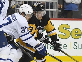 Maple Leafs' Timothy Liljegren and Pittsburgh Penguins' Brock McGinn battle for the puck during the second period of an NHL hockey game Saturday, Oct. 23, 2021, in Pittsburgh, Pa.