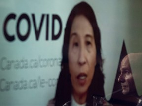 Canada's Chief Public Health Officer Theresa Tam appears at a news conference by video conference, as Health Minister Jean-Yves Duclos is reflected on a television screen, on Friday, November 26, 2021 in Ottawa.