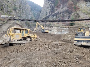 Crews work as CP Rail tracks are suspended above the washed out Tank Hill underpass of the Trans Canada Highway 1 after devastating rain storms caused flooding and landslides, northeast of Lytton, B.C., Nov. 20, 2021.