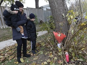 Amanda Lapier and her two sons, Alexandros, 3, and Lucas, 8, left flowers and a candle at the scene of a crash that killed a five-year-old girl on Renforth Dr.