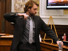 Using a microphone as a prop for his Glock handgun, shooting victim Gaige Grosskreutz shows the jury how he was holding the gun in his right hand when he was shot during the Kyle Rittenhouse trial at the Kenosha County Courthouse on November 8, 2021 in Kenosha, Wisconsin.