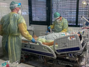 Medical staff members of Munchen Klinik Schwabing hospital take care of a patient infected with COVID-19 in the intensive care unit in Munich, Germany, Nov. 12, 2021.