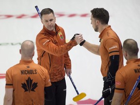 Skip Brad Gushue celebrates with second Brett Gallant, lead Geoff Walker and third Mark Nichols after defeating Brad Jacobs 7-6 in extra ends.