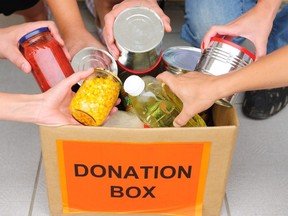 People putting food in a donation box.