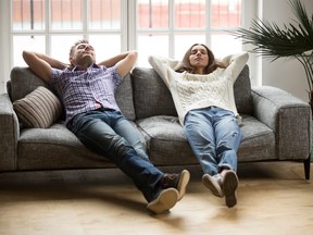 Young couple relaxing together on sofa enjoying nap breathing air