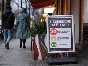 A '2G' rule sign, allowing only those vaccinated or recovered from the coronavirus disease (COVID-19) to enter restaurants and other indoor areas, is displayed at the entrance of a cafe in Berlin, Germany, November 20, 2021.