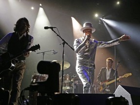 The late, great Gord Downie, centre, performs with The Tragically Hip in Edmonton in 2016. The band re-releases its iconic Road Apples album in digital form on Friday. POSTMEDIA FILES