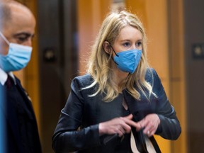 Theranos founder Elizabeth Holmes collects her belongings after arriving to attend her fraud trial at federal court in San Jose, Calif., Nov. 17, 2021.