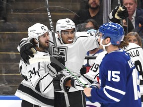 Los Angeles Kings forward Andreas Athanasiou (22) celebrates with forwards Phillip Danault (left) and Alex Iafallo (obscured) after scoring against the Maple Leafs in the first period at Scotiabank Arena on Monday, Nov. 11, 2021.