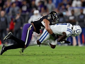 Parris Campbell, right, of the Indianapolis Colts is tackled by Malik Harrison of the Baltimore Ravens during the first quarter in a game  at M&T Bank Stadium on Oct. 11, 2021 in Baltimore.