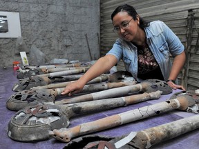 An archaeologist shows incense burners, part of an altar unearthed by archaeologists at a plot near Plaza Garibaldi in downtown Mexico City, in this photo distributed to Reuters by the National Institute of Anthropology and History on November 30, 2021.