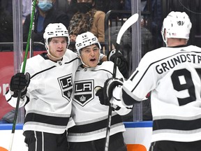 Los Angeles Kings forward Trevor Moore (12) celebrates with defenceman Tobias Bjornfot (left) and forward Carl Grundstrm after scoring against Maple Leafs -- his former team -- in the first period at Scotiabank Arena on Monday, Nov. 11, 2021.