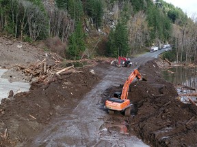 A work crew clears Highway 7 after devastating rain storms caused flooding and landslides, east of Agassiz, British Columbia, November 16, 2021