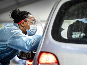 An employee of the Public Health Service of the Netherlands (GGD) carries out a test for Covid-19 in a street testing centre in the Hague, on November 17, 2021.