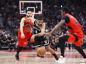 Patty Mills of the Brooklyn Nets dribbles his way through Fred VanVleet   (left) and Pascal Siakam of the Raptors during the first half at Scotiabank Arena on Nov. 7, 2021.