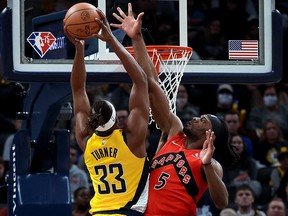 Myles Turner of the Indiana Pacers dunks the ball over Precious Achiuwa of the Toronto Raptors at Gainbridge Fieldhouse on November 26, 2021 in Indianapolis, Indiana.